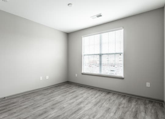 an empty room with a large window and wood floorsat Bella Vista Apartments, Fishers 46038