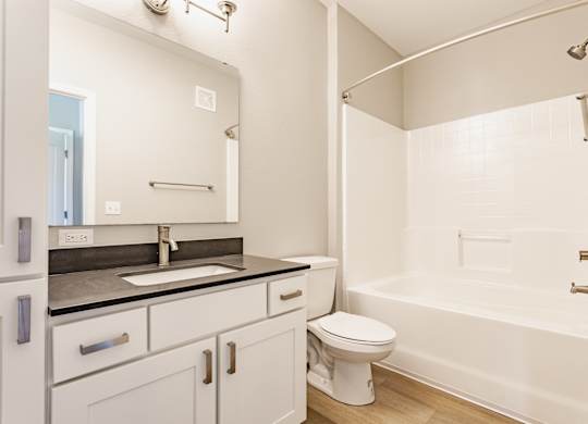 A white bathroom with a sink, toilet, and bathtub.