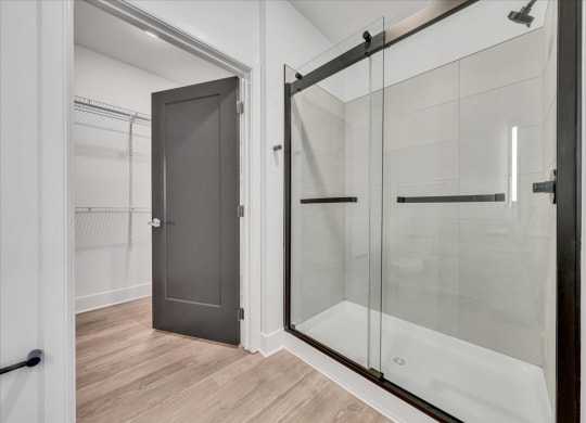 a bathroom with a shower and a door to a closet