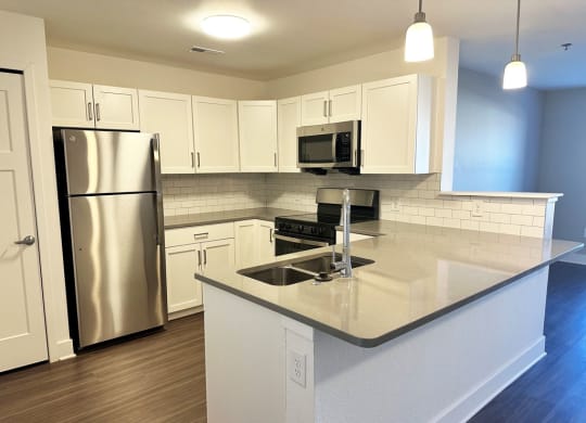 Modern kitchen with white shaker-style cabinets and stainless steel appliances  at Signature Pointe Apartment Homes, Athens, Alabama