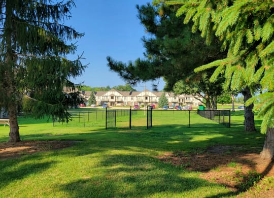 a large grassy area with trees in the foreground and houses in the background at Beacon Hill and Great Oaks Apartments, Illinois