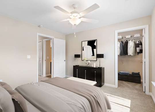 A bedroom with a bed, mirror, and closet.