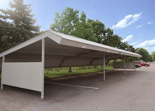 A large white carport with a metal roof is situated in a gravel pa at Northport Apartments, Macomb, MI, 48044rking lot