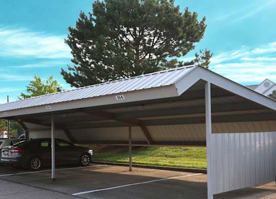 A carport with a metal roof and a car parked under it at The Harbours Apartments, Clinton Twp