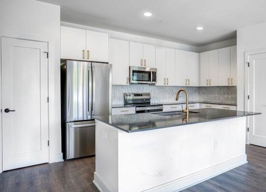 A modern kitchen with white cabinets and a central island.