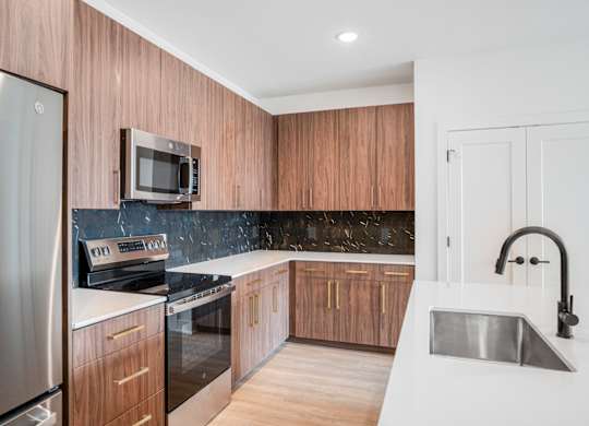 A modern kitchen with wooden cabinets and stainless steel appliances.