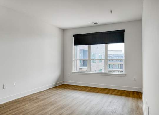 A room with a window and wooden flooring.