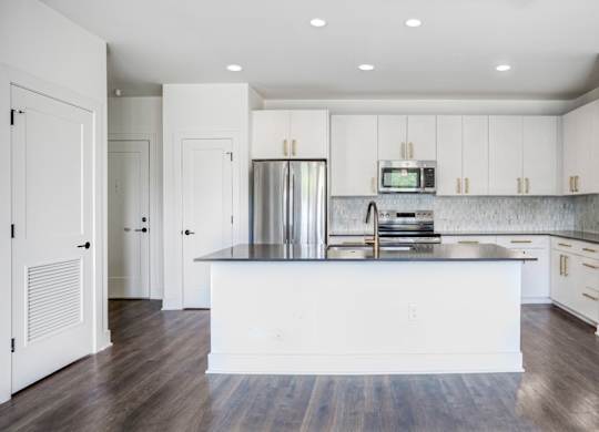 A modern kitchen with white cabinets and a central island.