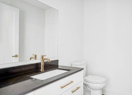 A white toilet sits next to a sink in a bathroom.