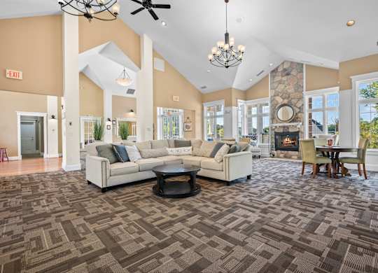 A spacious living room with a patterned carpet and a fireplacek at Timberlane Apartments, Peoria, Illinois