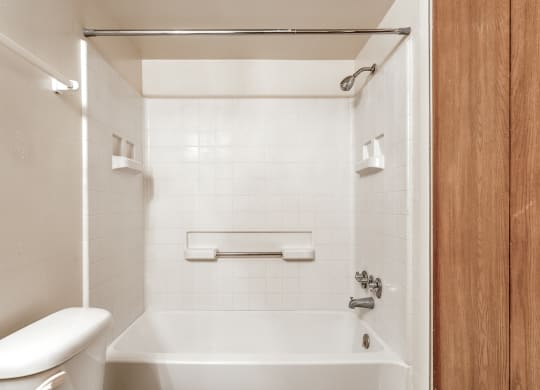 a bathroom with a toilet and a tub and a sink at Bay Pointe Apartments in Lafayette, IN 47909