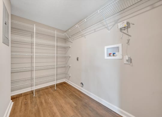 a room with a white wire shelving unit on the wall and a hardwood floor at Sunscape Apartments, Virginia, 24018
