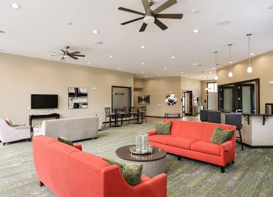 A living room with a red couch and a ceiling fan.