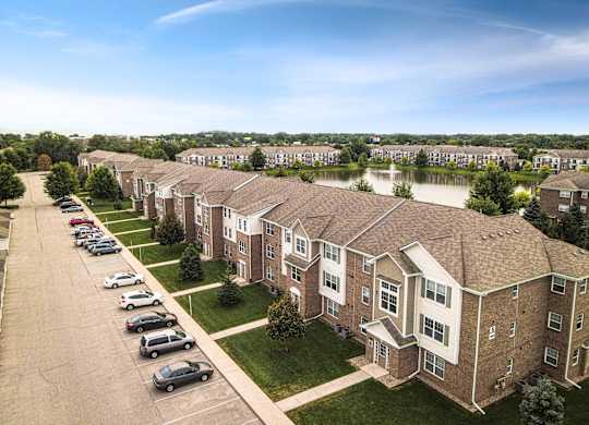 A row of houses with a parking lot in front at Towne Lakes Apartments, Grand Chute