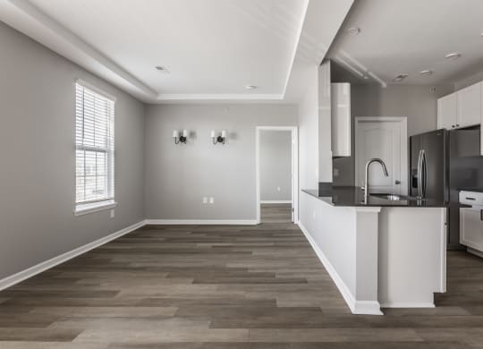 an open kitchen and living room with a large window and a black and white at Alexandria of Carmel Apartments, Carmel, Indiana