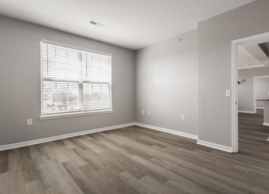 an empty living room with wood floors and a window at Alexandria of Carmel Apartments, Indiana, 46032
