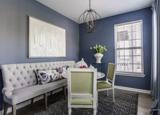 a flexspace with blue walls and a white couch and a table with two chairs at Alexandria of Carmel Apartments, Indiana, 46032