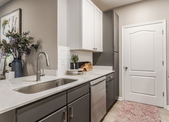 an empty kitchen with a sink and a door to a laundry room at Alexandria of Carmel Apartments, Carmel