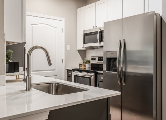 a kitchen with stainless steel appliances and a sink at Alexandria of Carmel Apartments, Indiana