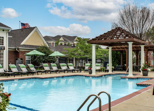a swimming pool with lounge chairs and a pavilion at Alexandria of Carmel Apartments, Carmel