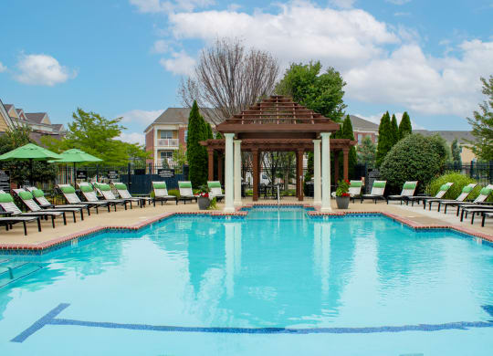 a pool with a gazebo and lounge chairs at Alexandria of Carmel Apartments, Indiana