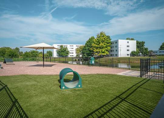 A playground with a green slide and a white building in the background at Alexandria of Carmel Apartments, Carmel, Indiana
