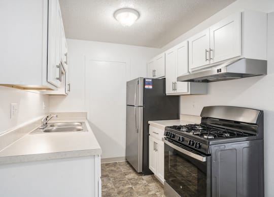a kitchen with stainless steel appliances and white cabinets at Apple Ridge Apartments, Michigan, 49534