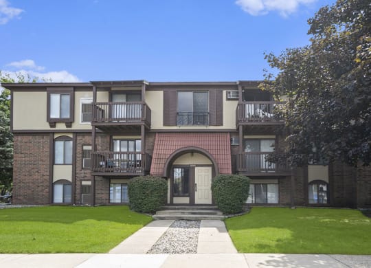 front view of building with green grass and trees at Apple Ridge Apartments, Michigan, 49534
