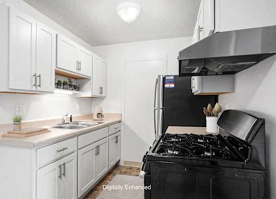 An upgraded kitchen with white cabinets and stainless steel appliances  at Apple Ridge Apartments, Walker, MI