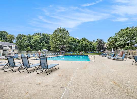 A resort-style pool surrounded by chairs at Apple Ridge Apartments, Michigan, 49534