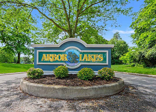 A sign for Arbor Lakes is displayed in front of a tree at Arbor Lakes Apartments in Elkhart, IN