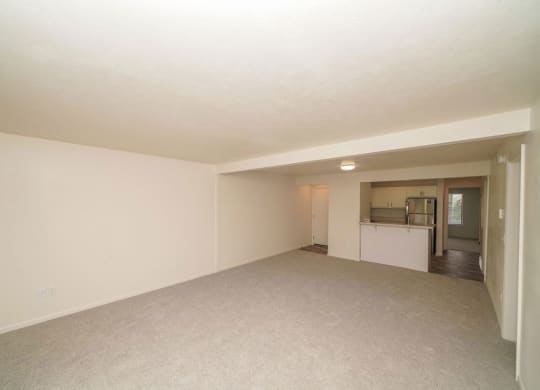 an empty living room with a kitchen in the backgroundat Arbor Lakes Apartments in Elkhart, IN