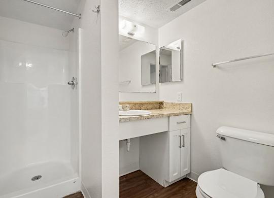 A white bathroom with a shower, toilet, and sink at Autumn Lakes Apartments and Townhomes, Mishawaka, 46544