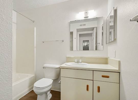 A bathroom with a toilet, sink, and mirror at Autumn Lakes Apartments and Townhomes, Mishawaka, 46544