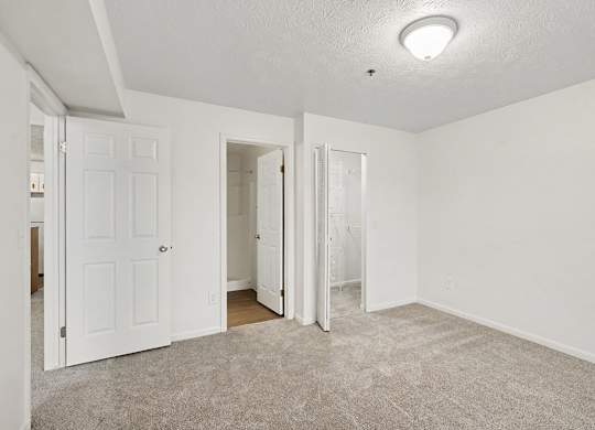 A bedroom with white walls, a walk-in closet and ensuite bathroom at Autumn Lakes Apartments and Townhomes, Mishawaka, 46544