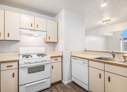 a kitchen with white appliances and wooden cabinets at Autumn Lakes Apartments and Townhomes, Mishawaka, 46544
