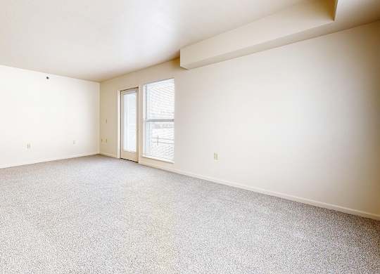 An end style living room with a carpeted floor and a door leading to a patio at Autumn Lakes Apartments and Townhomes in Mishawaka, IN
