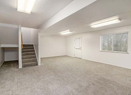 A spacious room with a staircase and a window with blinds at Autumn Lakes Apartments and Townhomes, Mishawaka, 46544