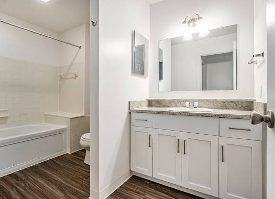 A white bathroom with a tub, toilet, and sink at Autumn Lakes Apartments and Townhomes, Mishawaka, 46544