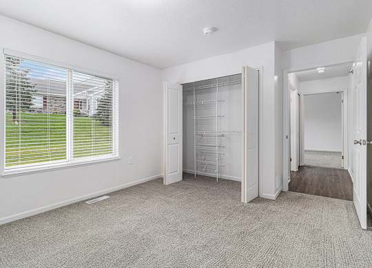 A bedroom with a walk-in closet and a window with blinds at Autumn Lakes Apartments and Townhomes, Mishawaka, 46544