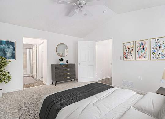 A bedroom with a large bed, a ceiling fan, and a high ceiling at Autumn Lakes Apartments and Townhomes, Mishawaka, 46544