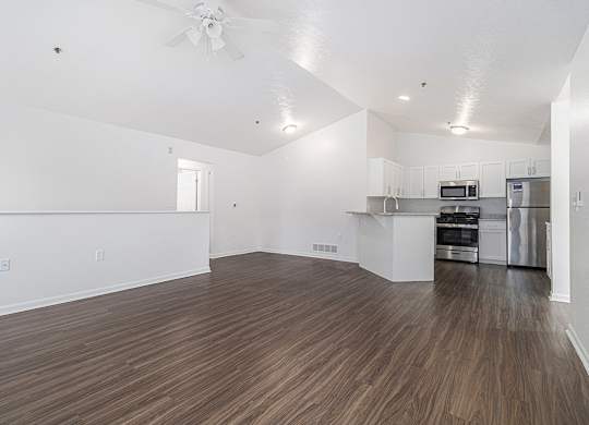 A large living and dining room with vinyl plank flooring and a kitchen in the background at Autumn Lakes Apartments and Townhomes, Mishawaka, 46544