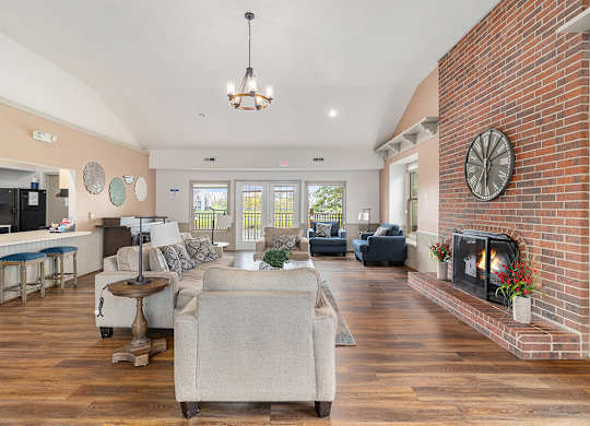 A community room with a fireplace and a couch at Autumn Lakes Apartments and Townhomes, Mishawaka, IN