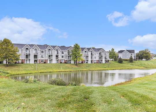 An exterior apartment building with a pond view at Autumn Lakes Apartments and Townhomes, Mishawaka, IN
