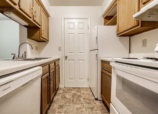 A kitchen with white appliances and wooden cabinets