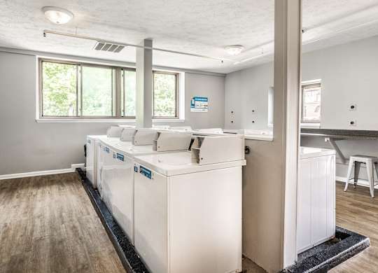 A kitchen with white appliances and wooden floors