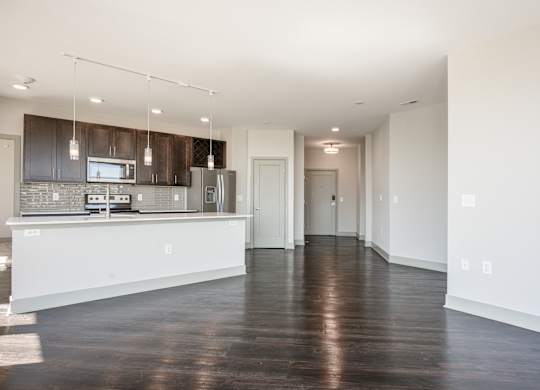 an empty kitchen and living room with white walls and wood floors at Avant & Avant II, Carmel, IN, 46032