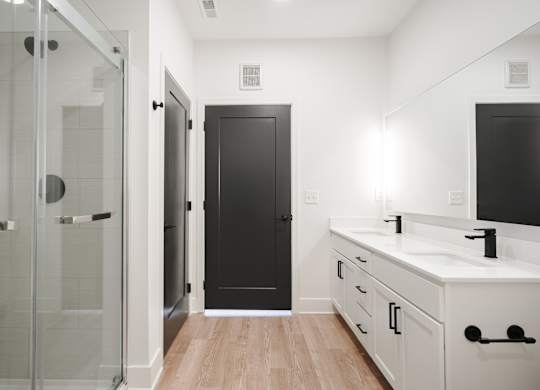 a bathroom with a sink and a shower and a black door at Avant & Avant II, Carmel, IN, 46032