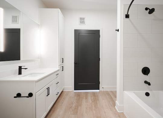 a bathroom with white cabinets and a black door     and a shower at Avant & Avant II, Carmel, IN, 46032
