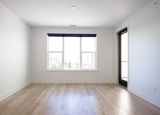 an empty living room with wood floors and a window at Avant & Avant II, Carmel, IN, 46032
